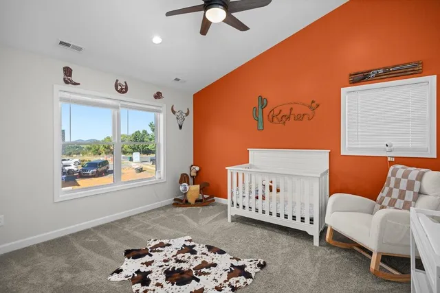 a bedroom with a dresser and a chandelier fan