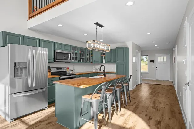 a dining room filled chandelier and wooden floor