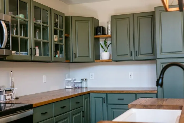 a kitchen with stainless steel appliances granite countertop a sink and cabinets with wooden floor