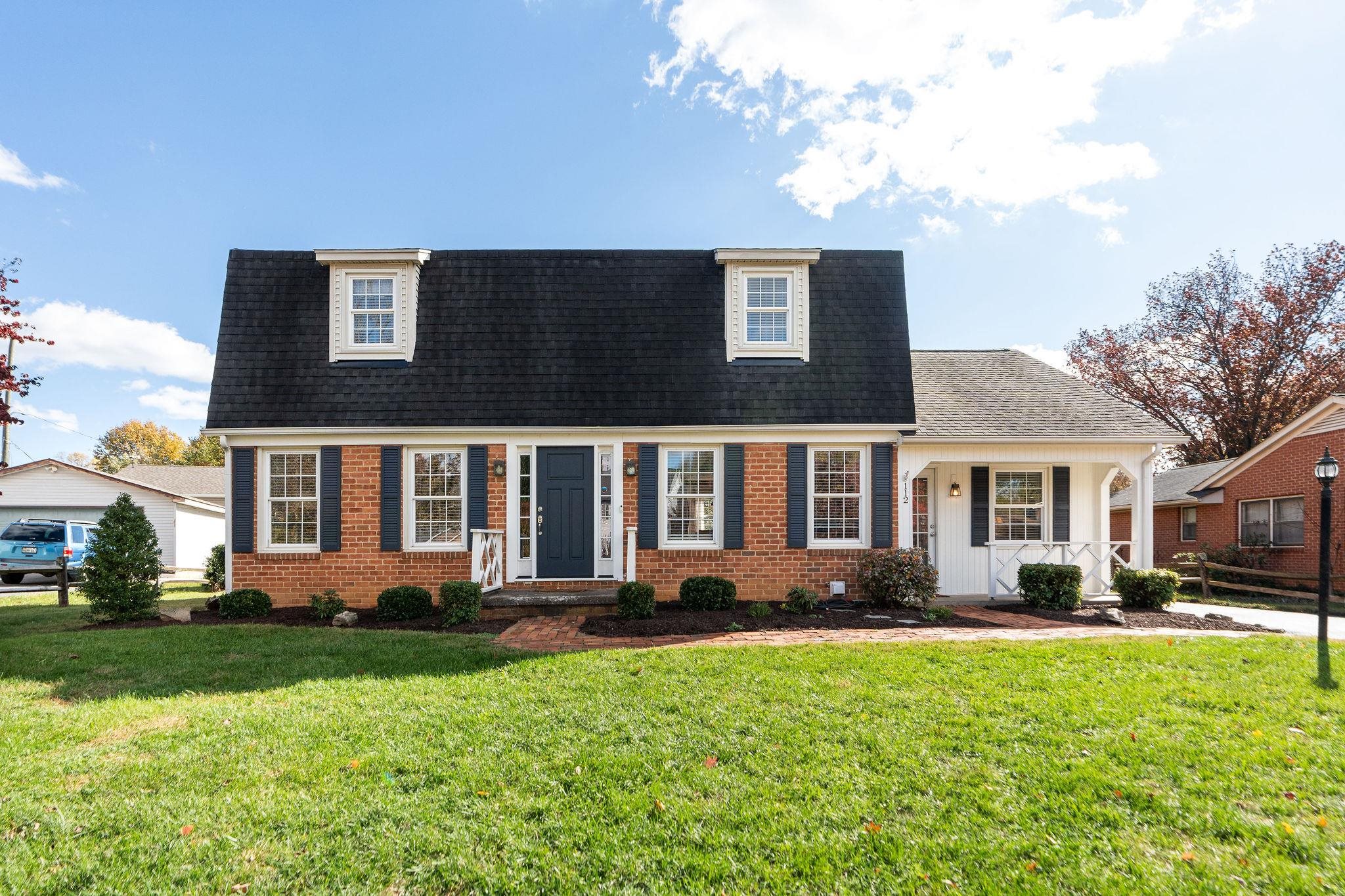 a front view of a house with a yard and potted plants