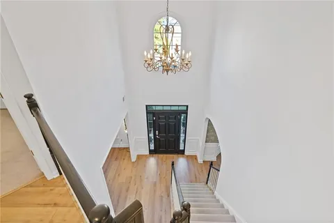 a large kitchen with stainless steel appliances granite countertop a sink dishwasher a stove and a refrigerator with wooden floor