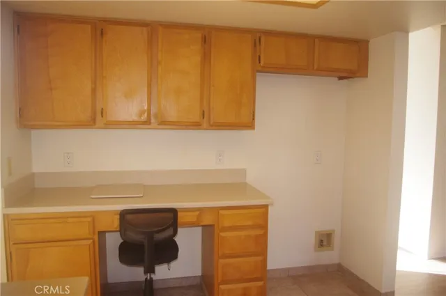 a kitchen with granite countertop a stove top oven a sink a dining table and chairs with wooden floor