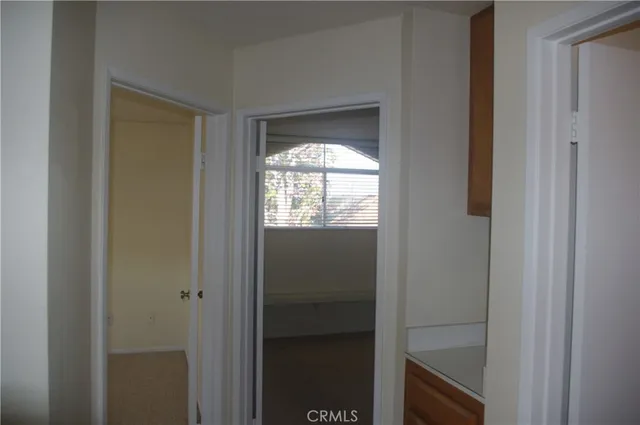 a view of an empty room with window and closet area