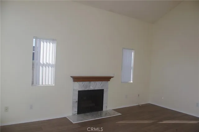 an empty room with windows and fireplace