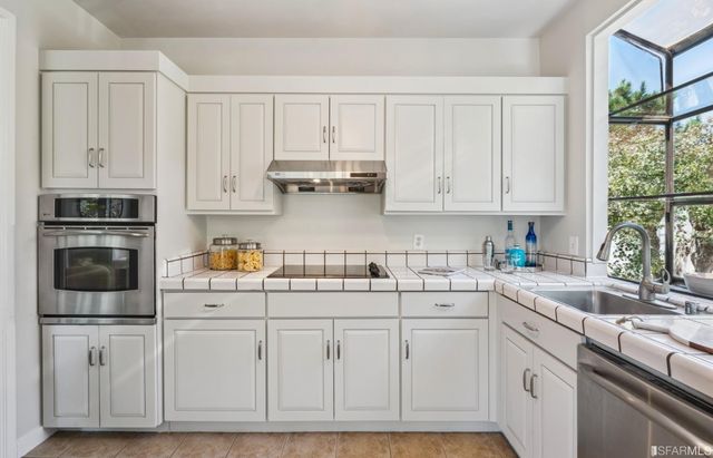 a kitchen with white cabinets and white appliances