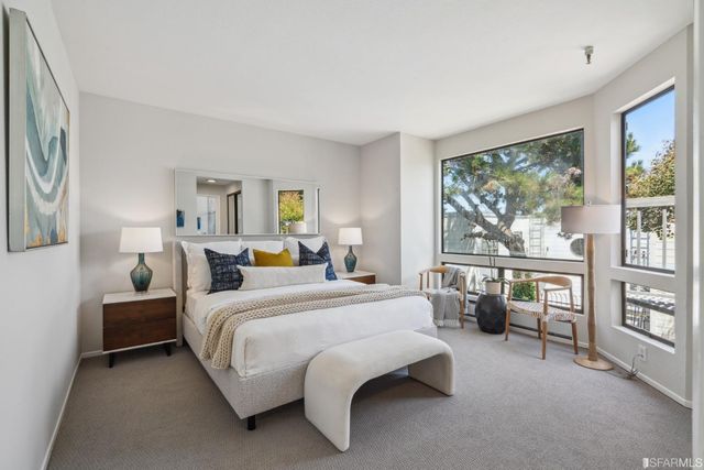 a bedroom with bed couch and window