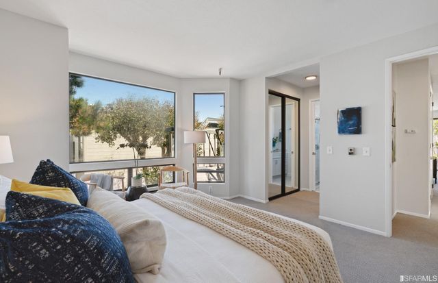 a bedroom with a bed and a large window
