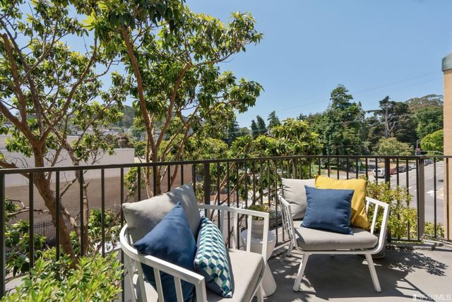 a balcony with wooden floor and outdoor seating