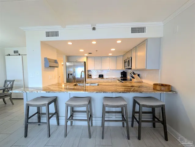 a kitchen with stainless steel appliances granite countertop table chairs sink and cabinets