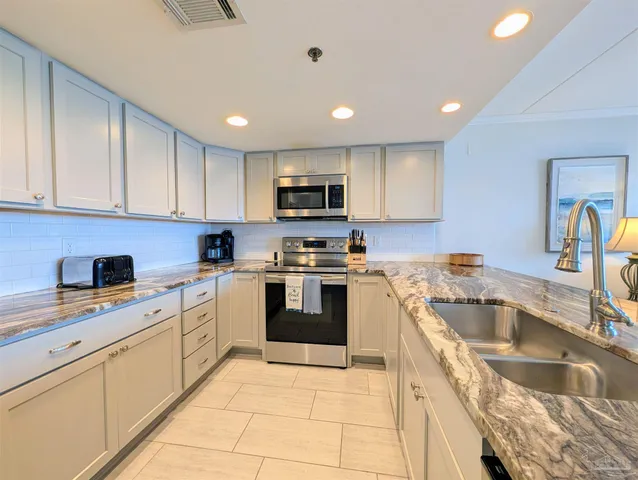 a kitchen with a sink stove top oven and cabinets
