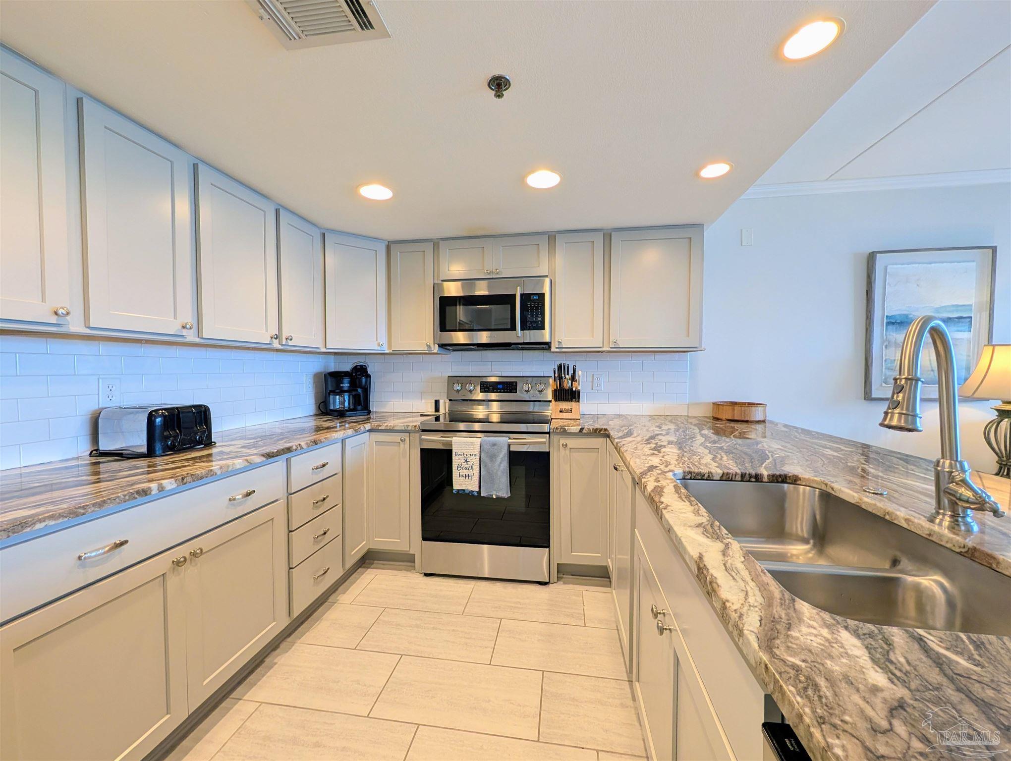 14623 Perdido Key Drive, Unit 401 Perdido Key, FL 32507 - Photo 13 of 40 a kitchen with a sink stove top oven and cabinets