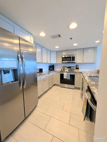 a kitchen with stainless steel appliances granite countertop a refrigerator sink and cabinets