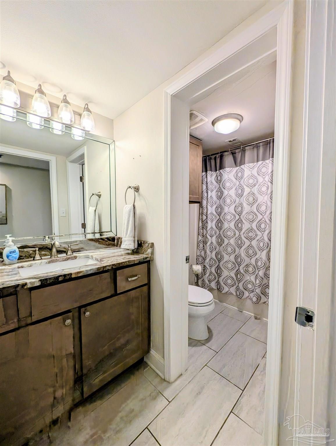 14623 Perdido Key Drive, Unit 401 Perdido Key, FL 32507 - Photo 26 of 40 a bathroom with a double vanity sink toilet and a mirror