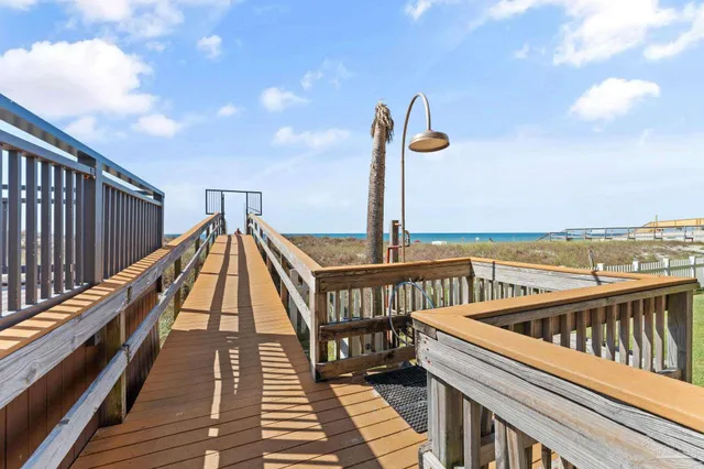 a view of a balcony with wooden floor and fence