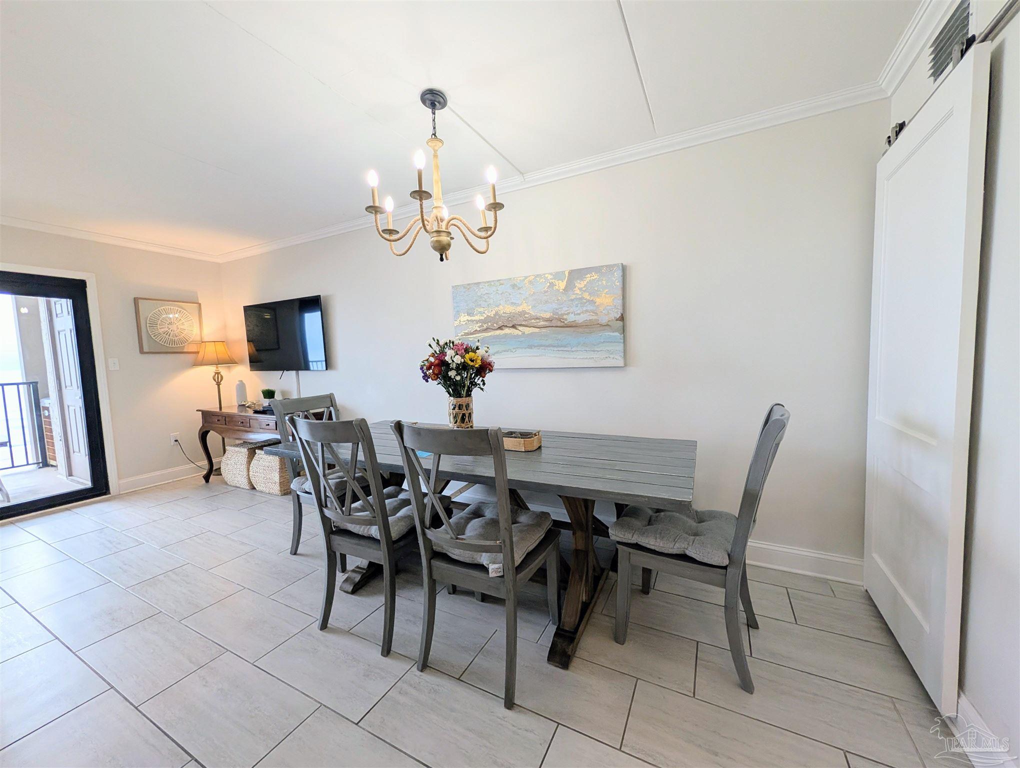 14623 Perdido Key Drive, Unit 401 Perdido Key, FL 32507 - Photo 7 of 40 a view of a dining room with furniture and chandelier