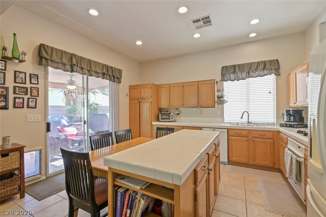 2356 Tilden Way Henderson, NV 89074 - Photo 10 of 30 A well-lit kitchen with a tiled island and direct outdoor access through sliding doors.