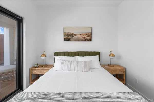 a bedroom with a bed and painting on the wall