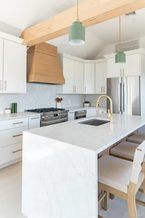 a kitchen with stainless steel appliances granite countertop a stove a sink and a refrigerator