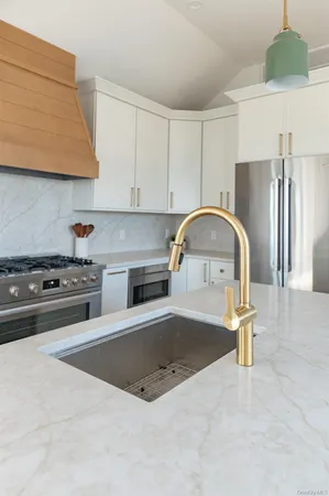 a stove sitting inside of a kitchen with white cabinets