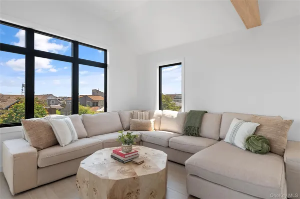 a living room with a large window and a potted plant