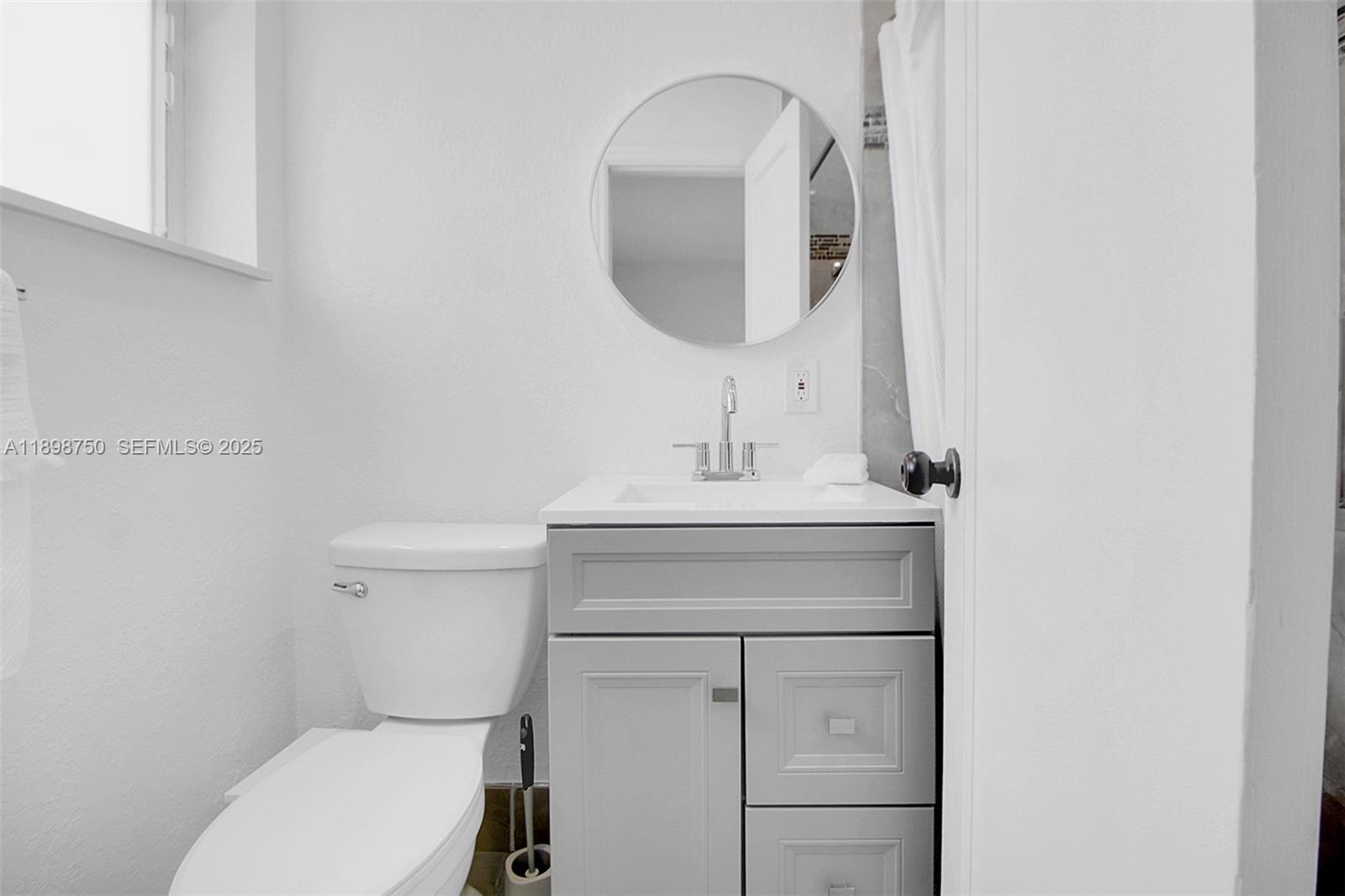231 Northeast 43rd Street Miami, FL 33137 - Photo 11 of 35 a bathroom with a toilet sink and mirror