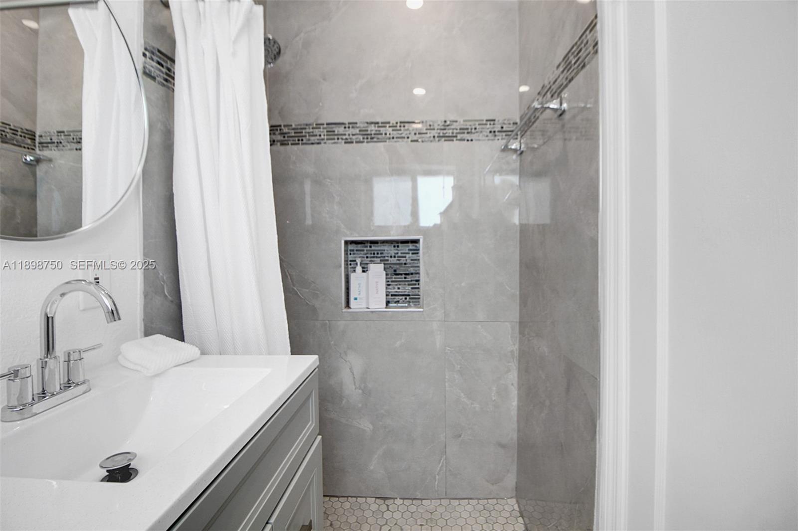 231 Northeast 43rd Street Miami, FL 33137 - Photo 12 of 35 a bathroom with a sink a mirror and shower