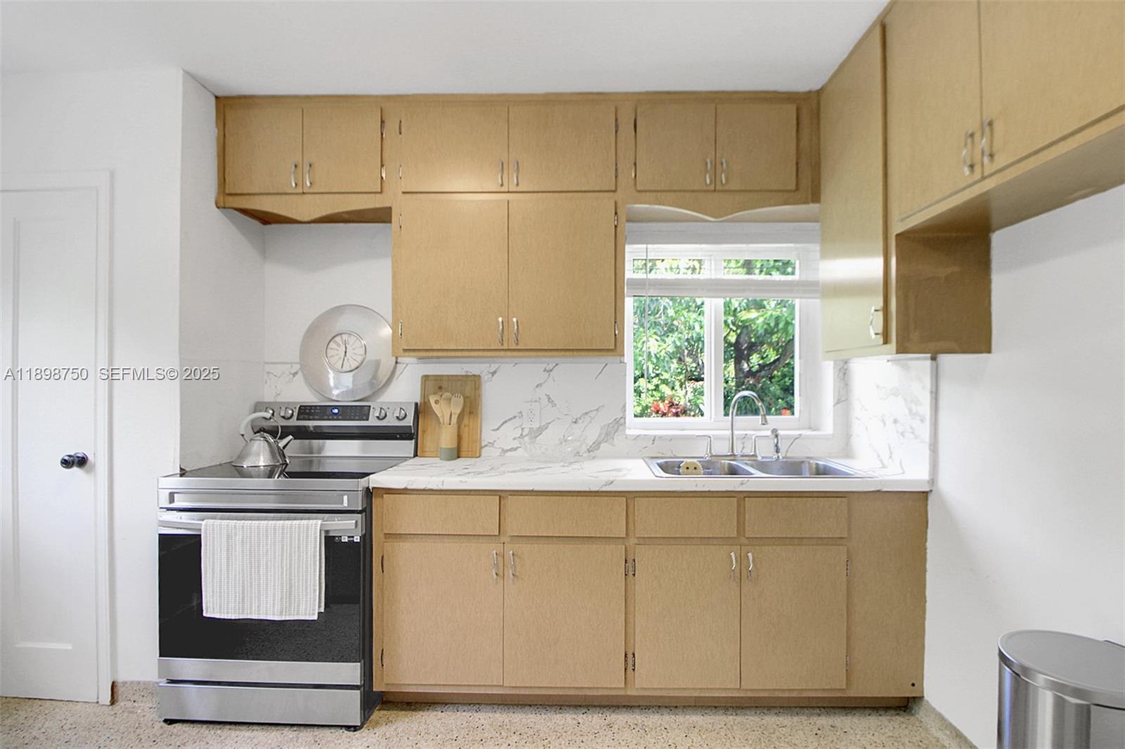 231 Northeast 43rd Street Miami, FL 33137 - Photo 18 of 35 a kitchen with stainless steel appliances white cabinets and a sink