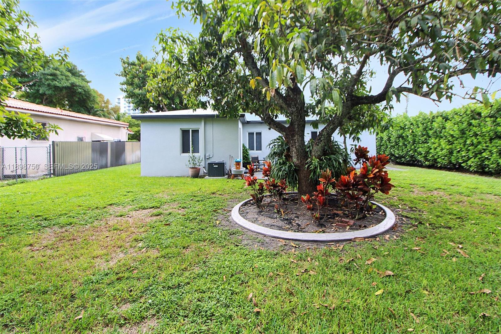 231 Northeast 43rd Street Miami, FL 33137 - Photo 30 of 35 a white house with a small yard and large trees