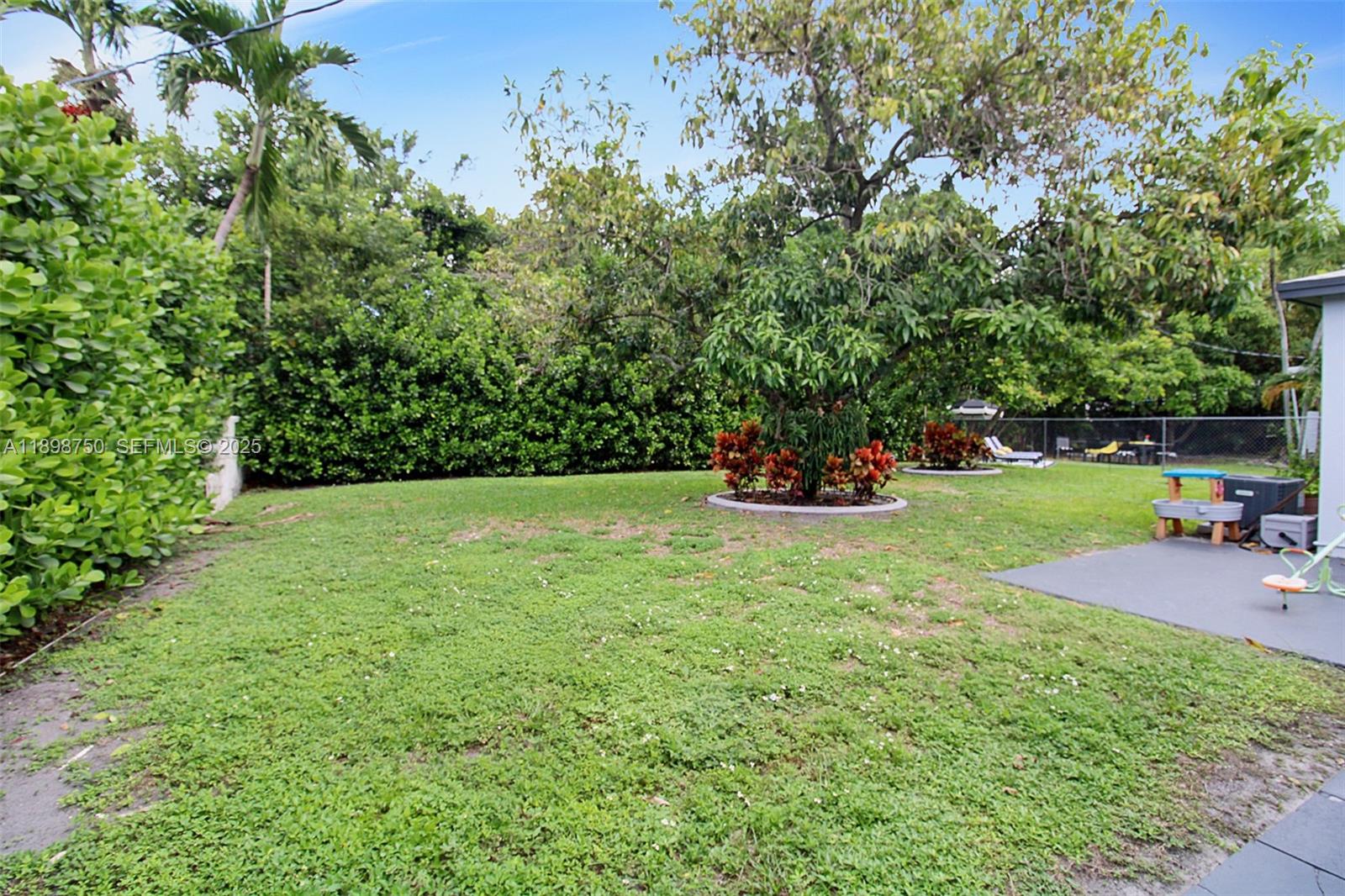 231 Northeast 43rd Street Miami, FL 33137 - Photo 33 of 35 a view of a backyard with wooden fence and a bench