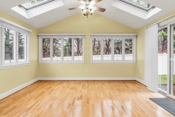 a view of a big room with wooden floor and windows