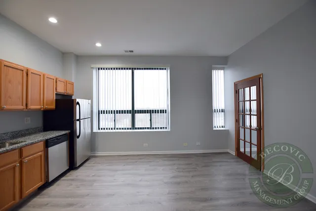 a kitchen with granite countertop a stove a sink and a refrigerator