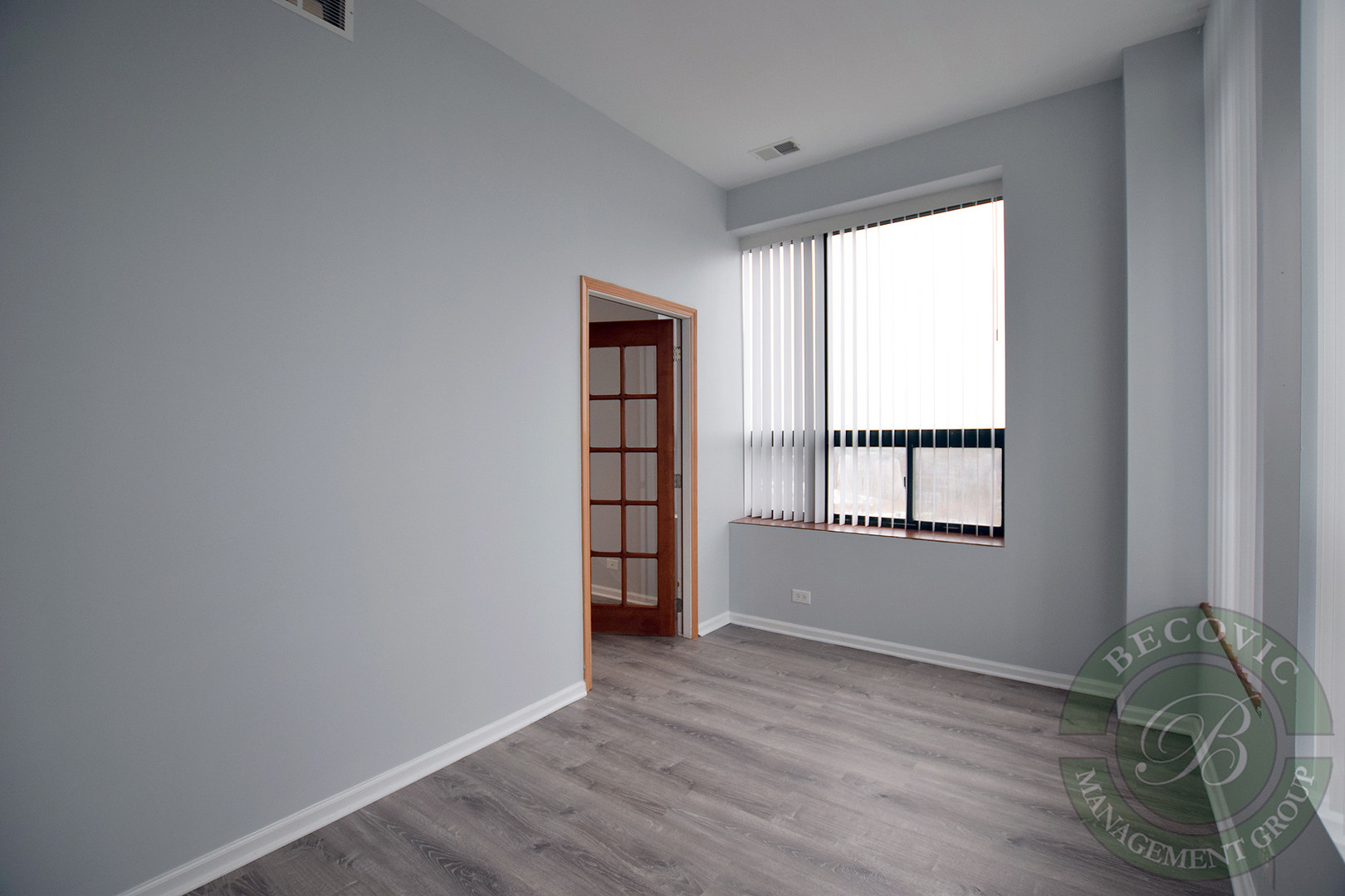2451 West Howard Street, Unit 601 Chicago, IL 60645 - Photo 5 of 6 an empty room with wooden floor and windows