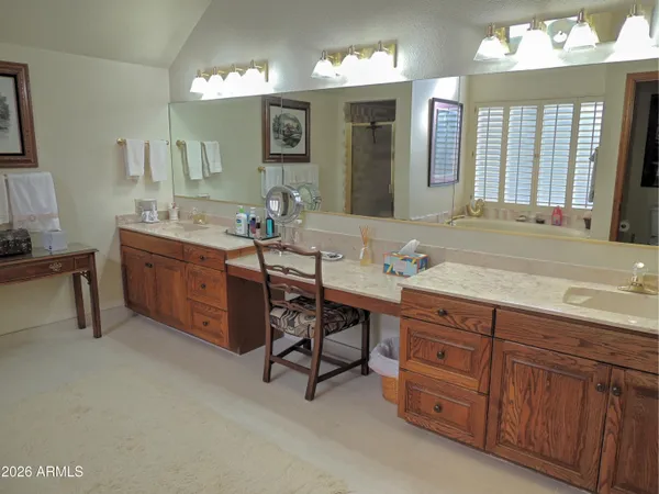 a spacious bedroom with a bed and a chandelier