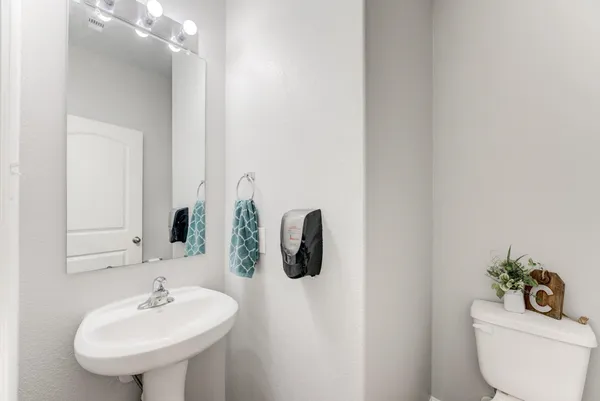 a bathroom with a toilet sink and mirror