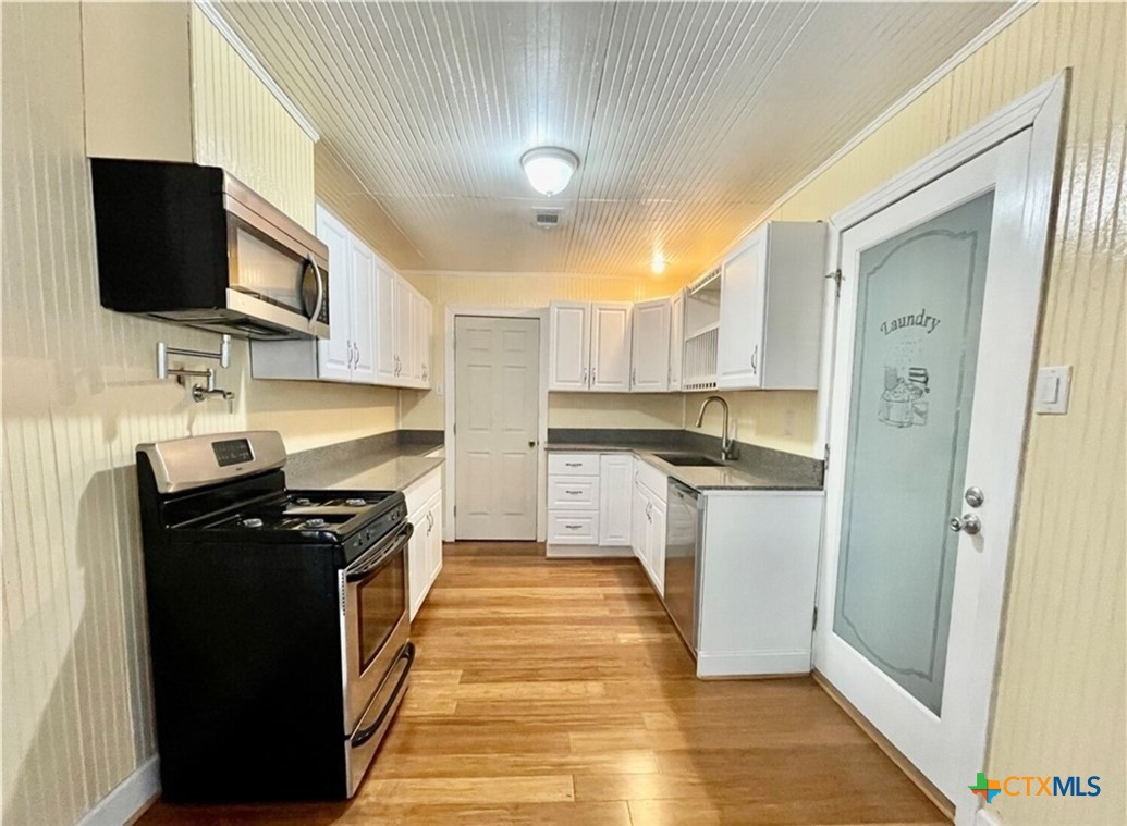 2001 East Forrest Street Victoria, TX 77901 - Photo 5 of 16 a kitchen with stainless steel appliances granite countertop a stove top oven a sink a refrigerator and a microwave