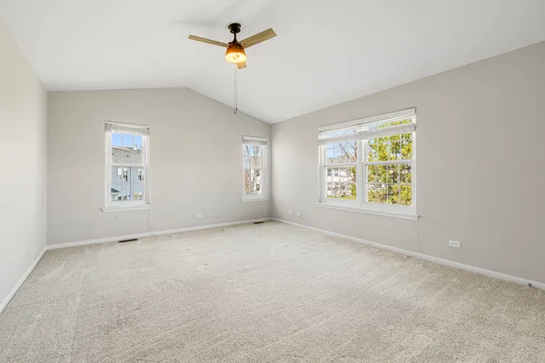 an empty room with a window and a ceiling fan