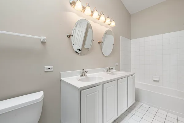 a bathroom with a double vanity sink mirror and toilet