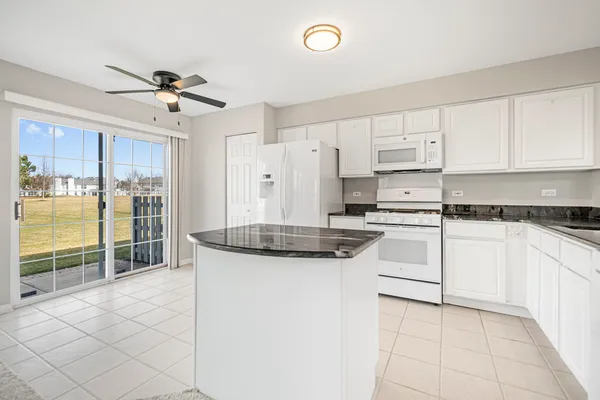 a kitchen with stainless steel appliances granite countertop a stove a sink and white cabinets
