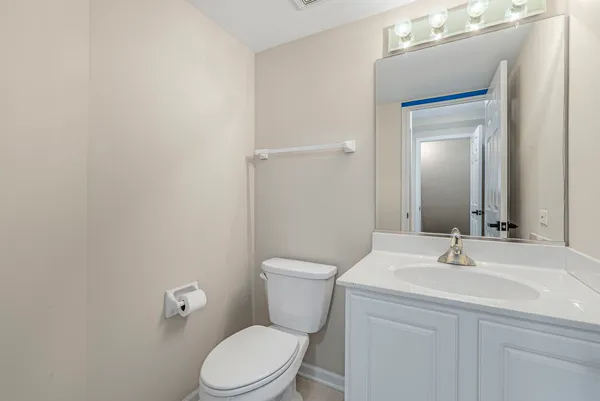 a bathroom with a toilet a sink a mirror and vanity