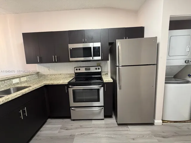 a view of a kitchen island a sink wooden floor and living room view
