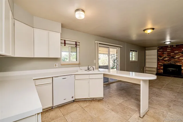 a large white kitchen with sink and cabinets