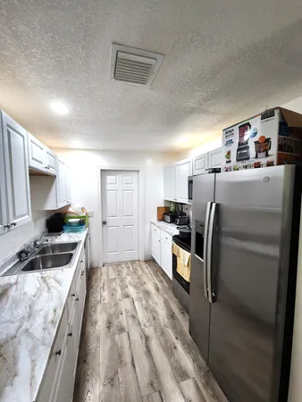 a kitchen with refrigerator and cabinets