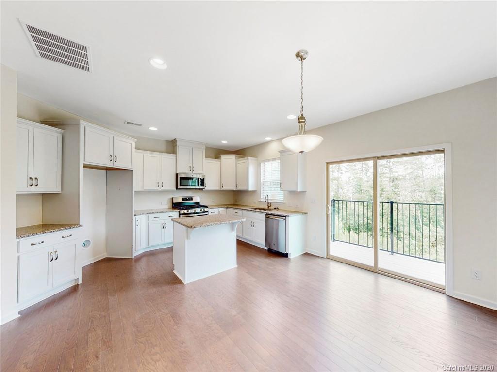 713 Swift Run Tega Cay, SC 29708 - Photo 5 of 8 a open kitchen with white cabinets and wooden floor