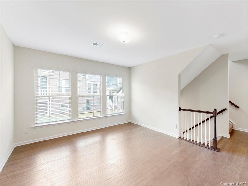 713 Swift Run Tega Cay, SC 29708 - Photo 6 of 8 an empty room with wooden floor and windows