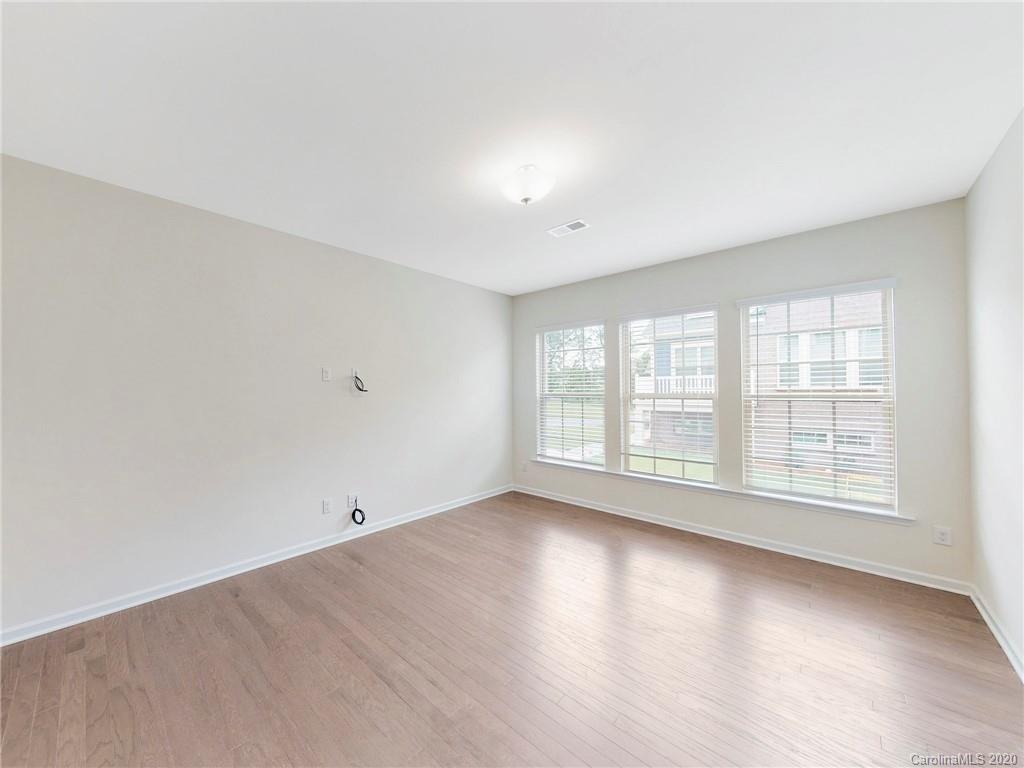 713 Swift Run Tega Cay, SC 29708 - Photo 7 of 8 an empty room with wooden floor and windows