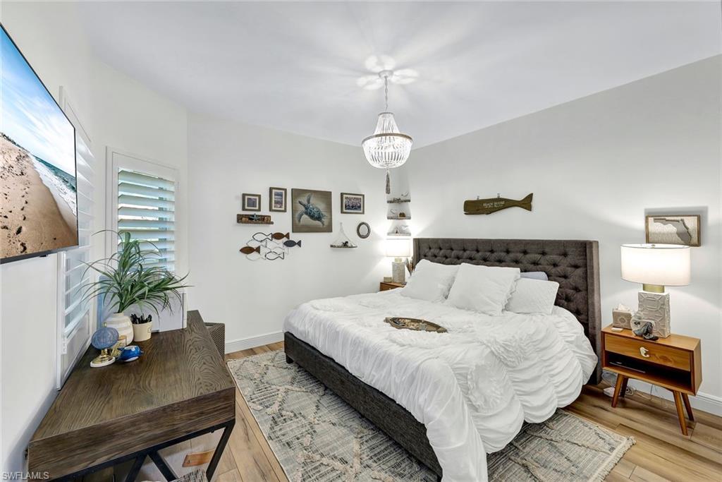 6549 Marissa Loop, Unit 21 Naples, FL 34108 - Photo 12 of 20 a bedroom with bed table and chair