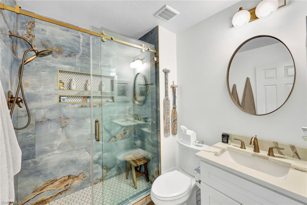 6549 Marissa Loop, Unit 21 Naples, FL 34108 - Photo 13 of 20 a bathroom with a toilet sink vanity granite and shower