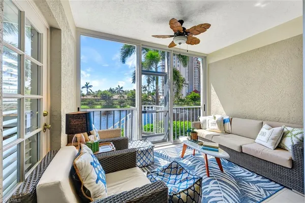 a living room with furniture ceiling fan and a large window