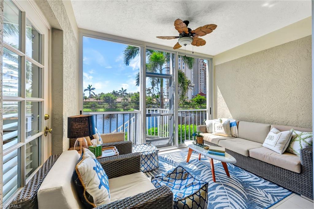 6549 Marissa Loop, Unit 21 Naples, FL 34108 - Photo 16 of 20 a living room with furniture ceiling fan and a large window