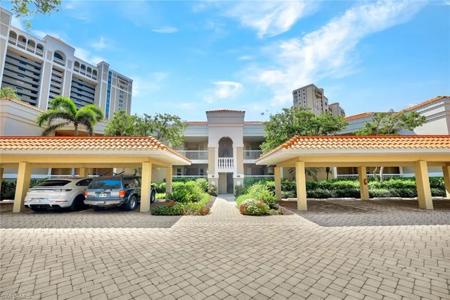a front view of a building with cars parked